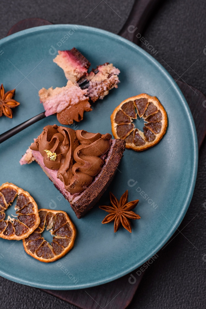 A imagem mostra uma fatia de bolo ou torta de chocolate, possivelmente com uma camada de recheio ou cobertura de cor diferente, decorada com rodelas de laranja