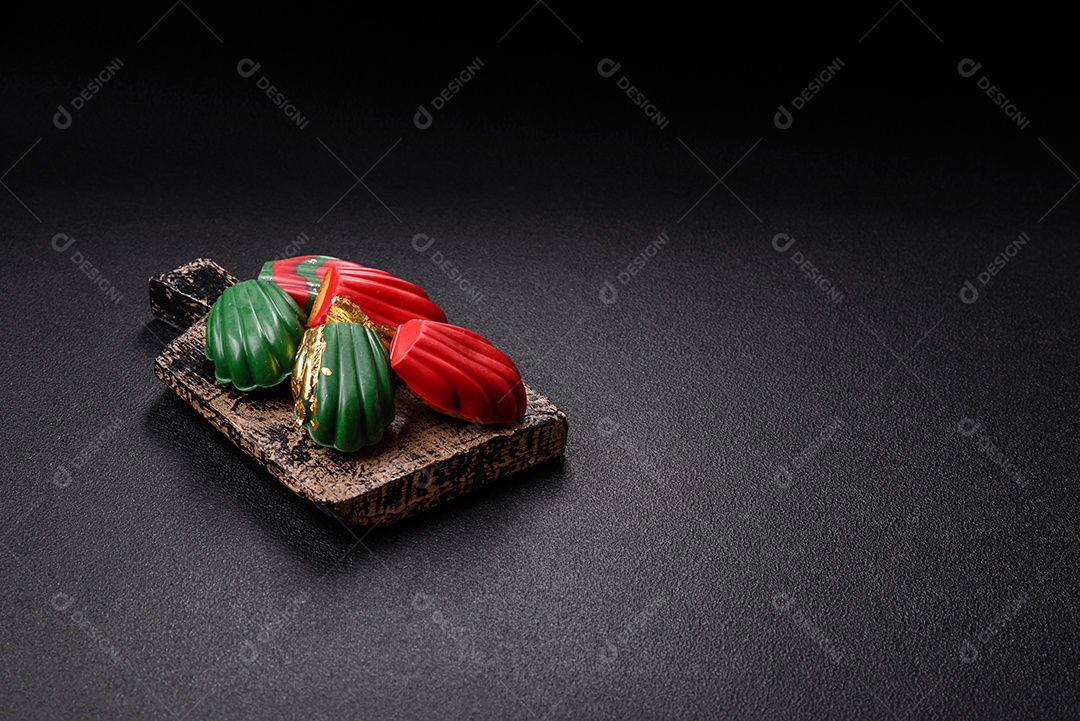 A imagem mostra madeleines doces cobertas com chocolate. As madeleines são pequenos bolos em forma de concha