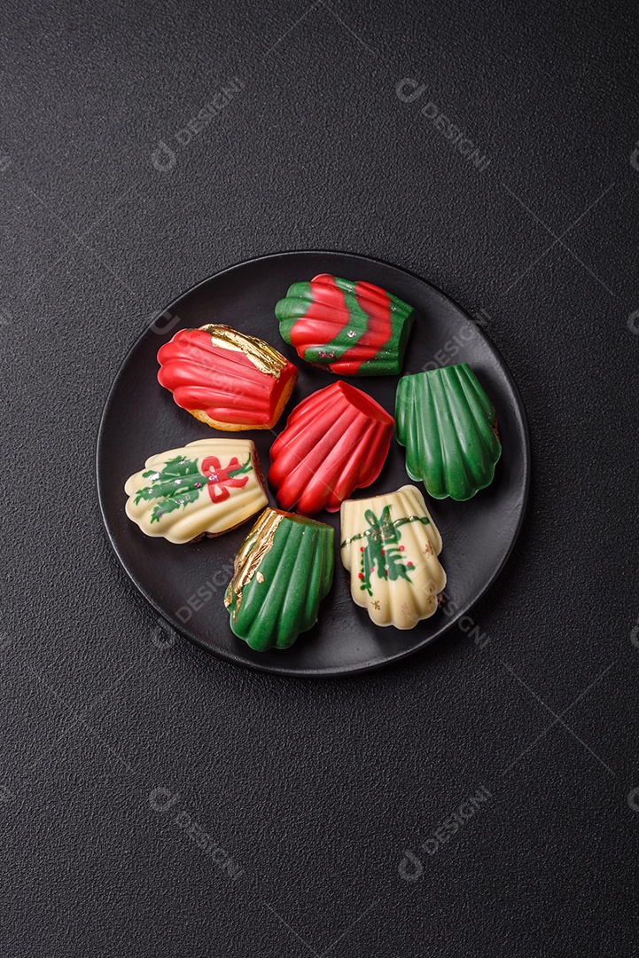 A imagem mostra madeleines doces cobertas com chocolate. As madeleines são pequenos bolos em forma de concha