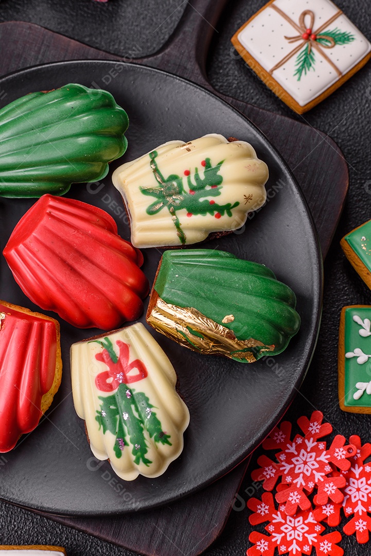 A imagem mostra uma caixa de madeira com biscoitos decorados com temas natalinos