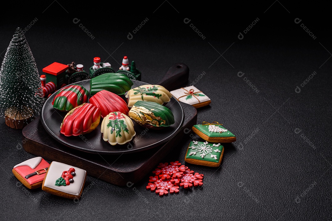 A imagem mostra uma caixa de madeira com biscoitos decorados com temas natalinos