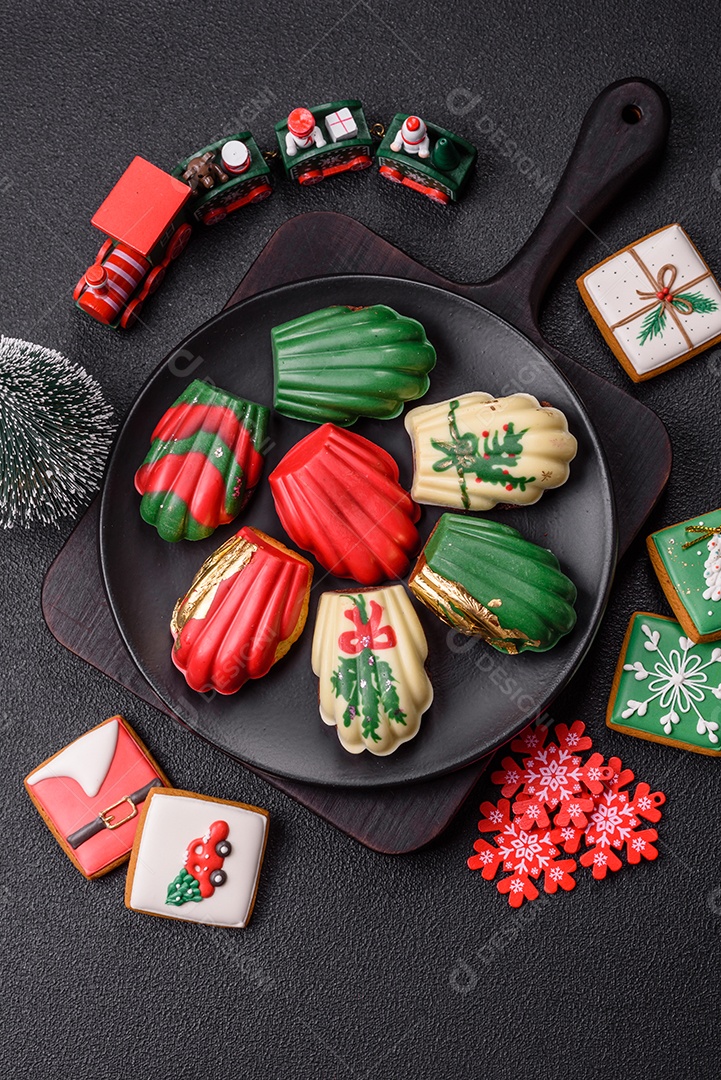 A imagem mostra uma caixa de madeira com biscoitos decorados com temas natalinos