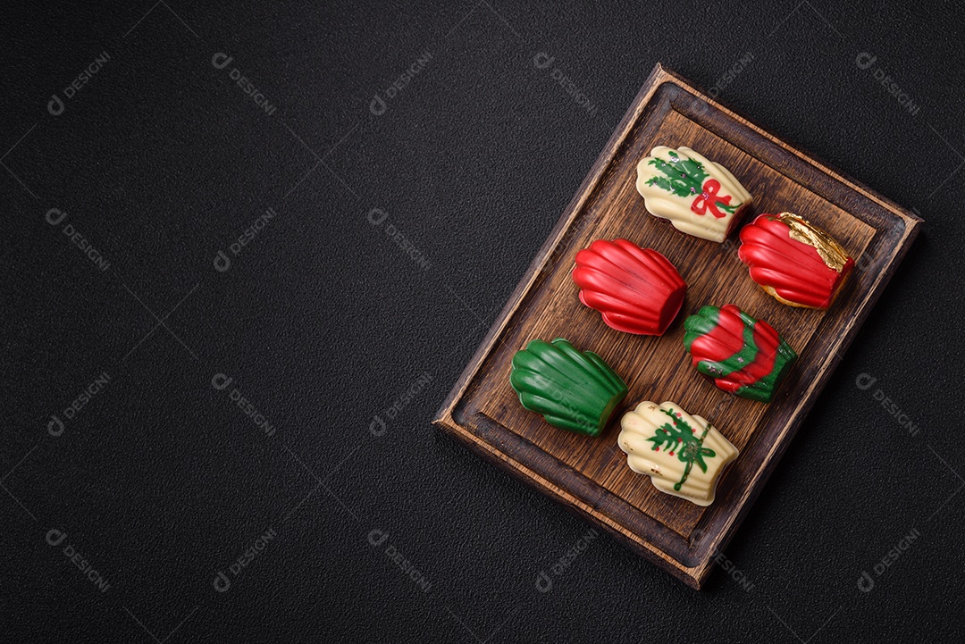 A imagem mostra uma caixa de madeira com biscoitos decorados com temas natalinos