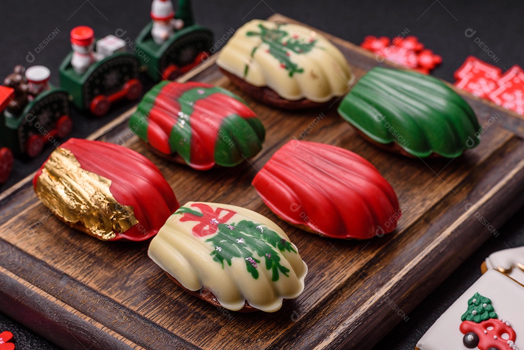 A imagem mostra uma caixa de madeira com biscoitos decorados com temas natalinos