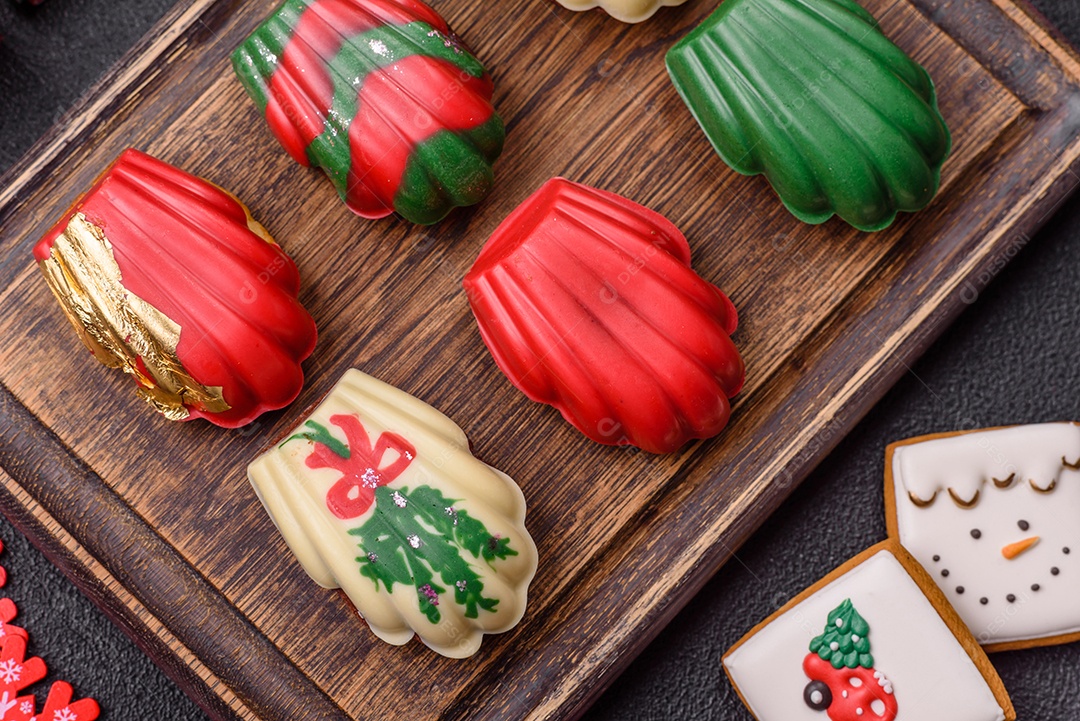 A imagem mostra uma caixa de madeira com biscoitos decorados com temas natalinos