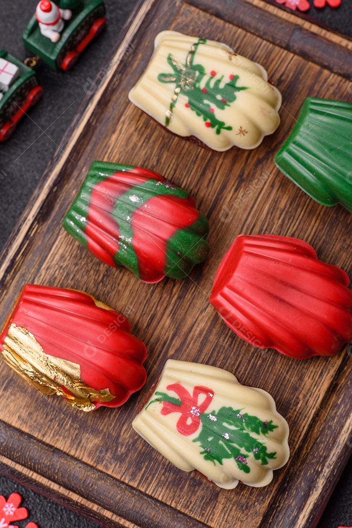 A imagem mostra uma caixa de madeira com biscoitos decorados com temas natalinos