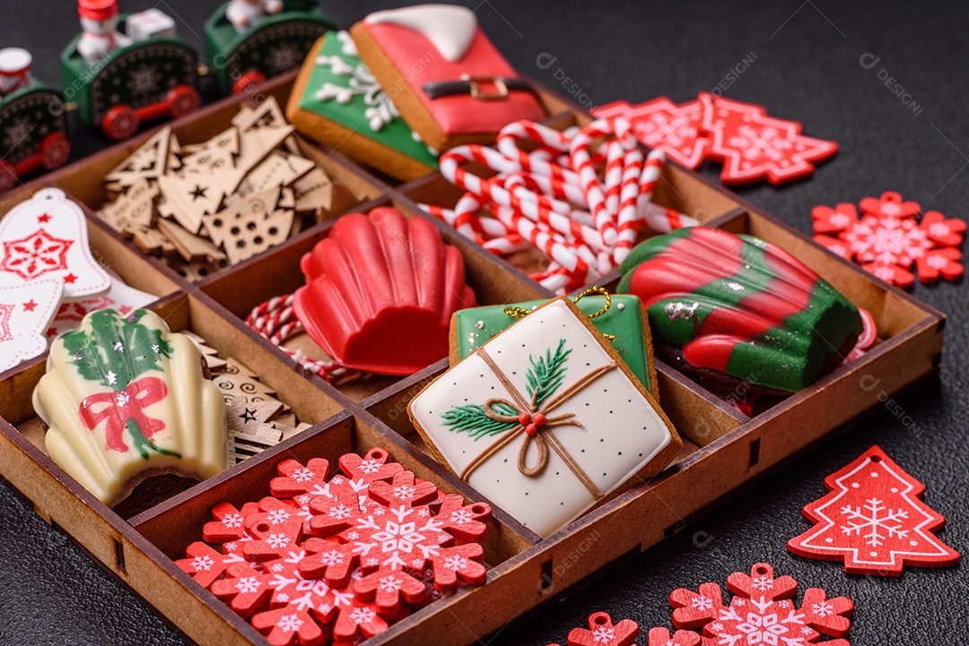 A imagem mostra uma caixa de madeira com biscoitos decorados com temas natalinos