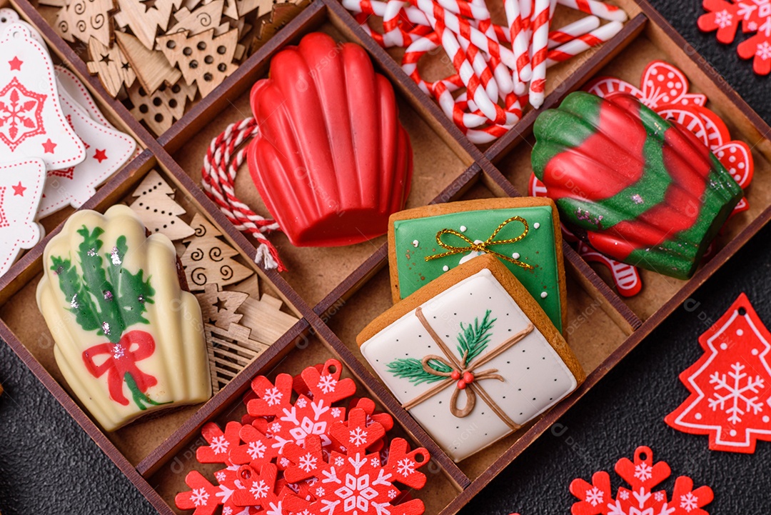 A imagem mostra uma caixa de madeira com biscoitos decorados com temas natalinos