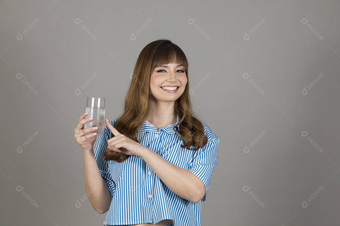 Linda mulher jovem sobre fundo isolado segurando copo de vidro com água