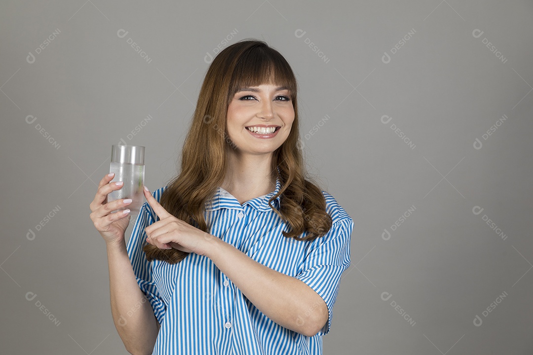 Linda mulher jovem sobre fundo isolado segurando copo de vidro com água