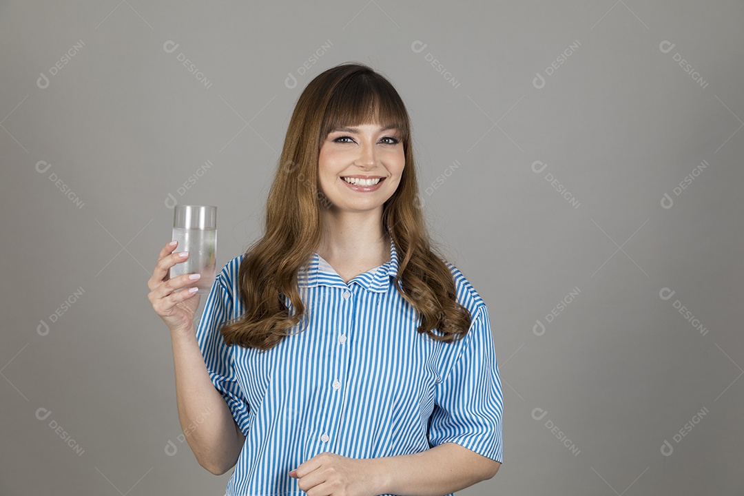 Linda mulher jovem sobre fundo isolado segurando copo de vidro com água