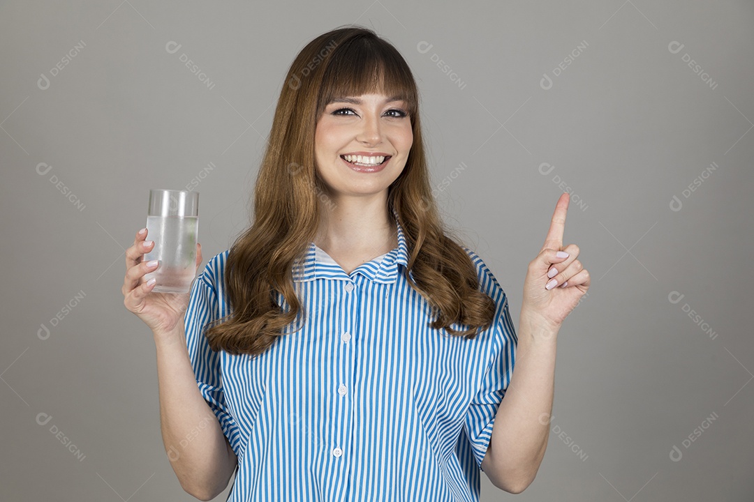Linda mulher jovem sobre fundo isolado segurando copo de vidro com água