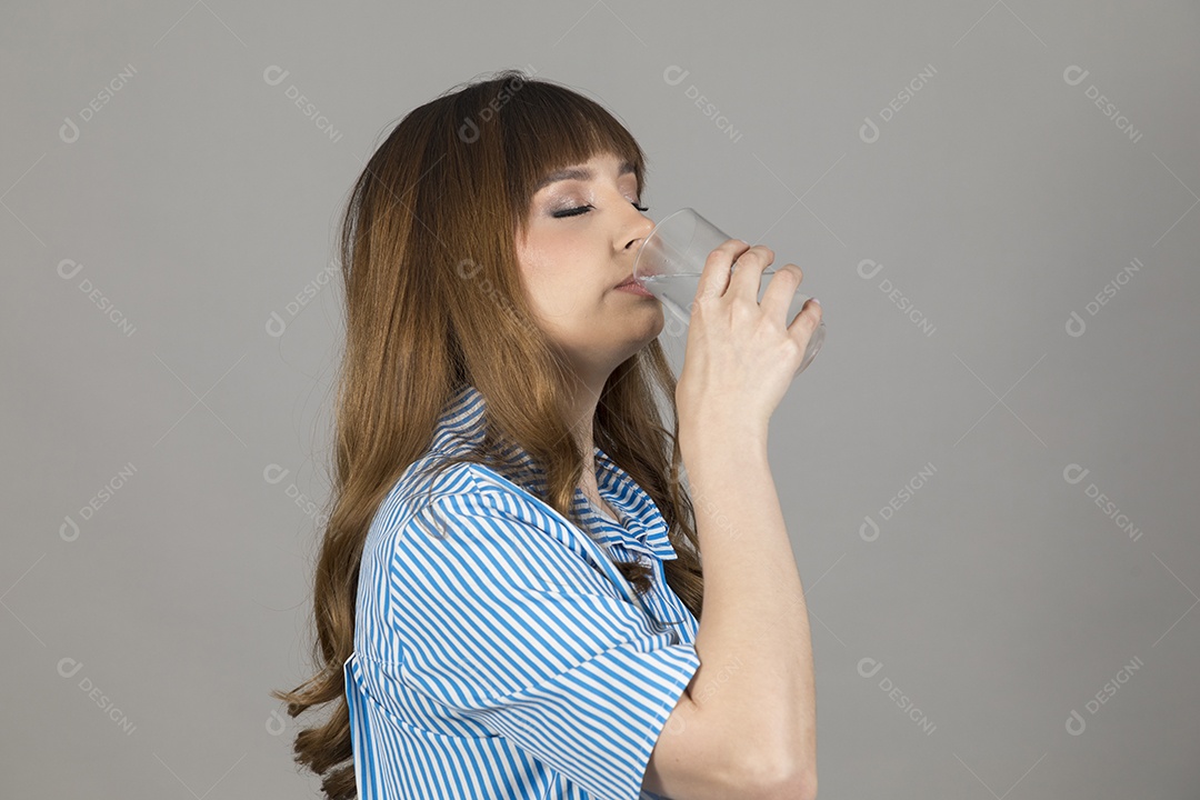 Linda mulher jovem sobre fundo isolado segurando copo de vidro com água