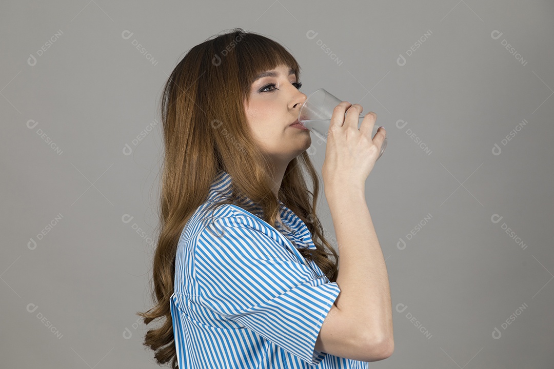 Linda mulher jovem sobre fundo isolado segurando copo de vidro com água