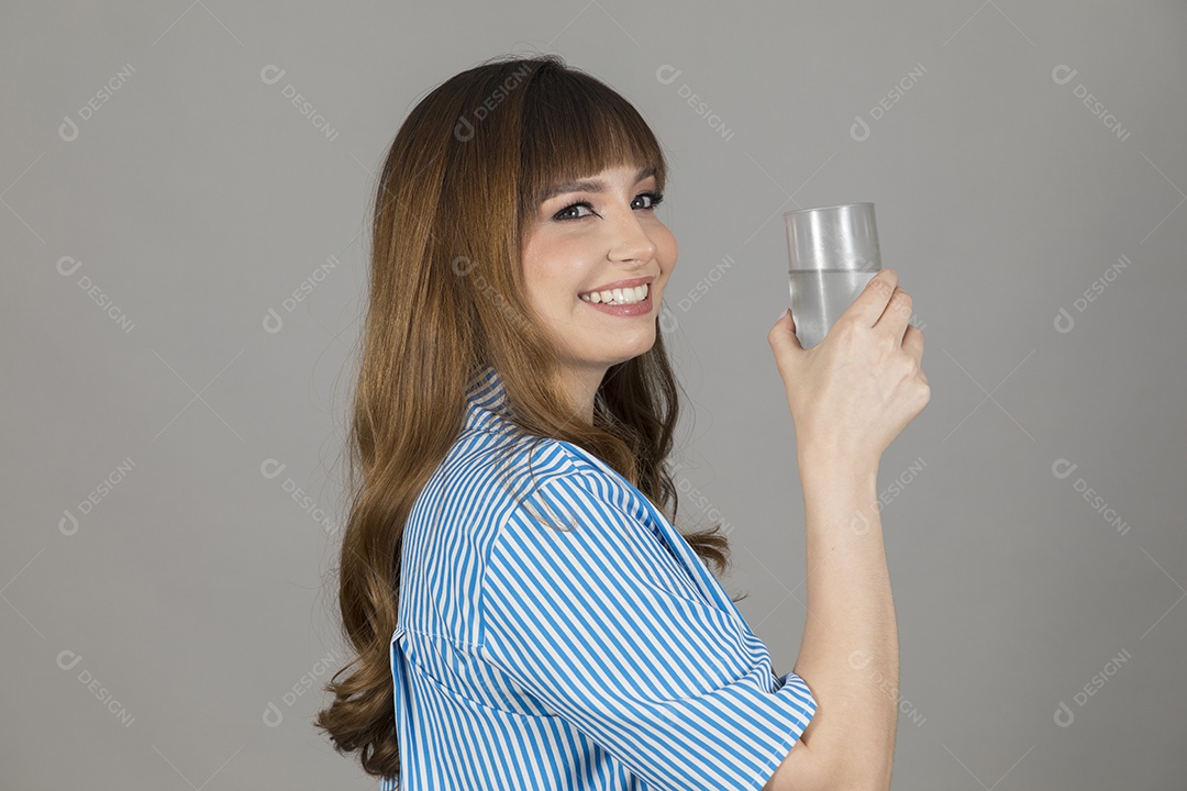 Linda mulher jovem sobre fundo isolado segurando copo de vidro com água