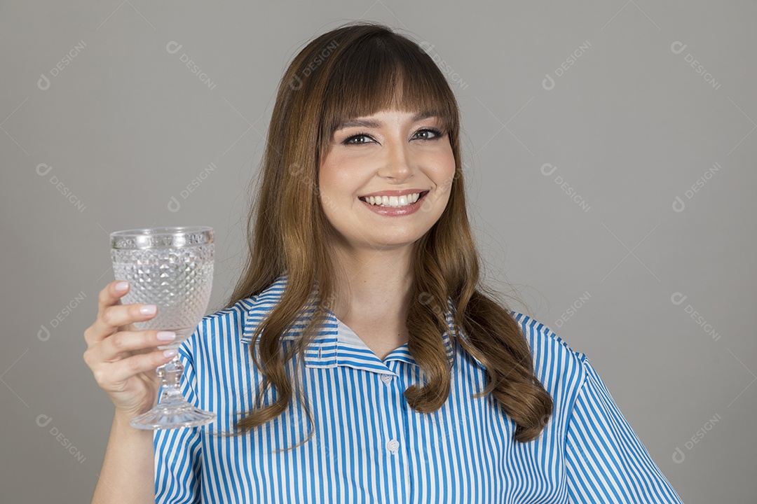 Linda mulher jovem sobre fundo isolado segurando copo de vidro com água