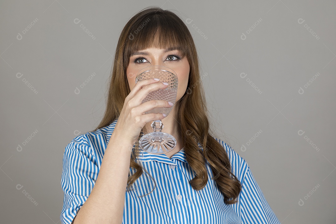 Linda mulher jovem sobre fundo isolado segurando copo de vidro com água