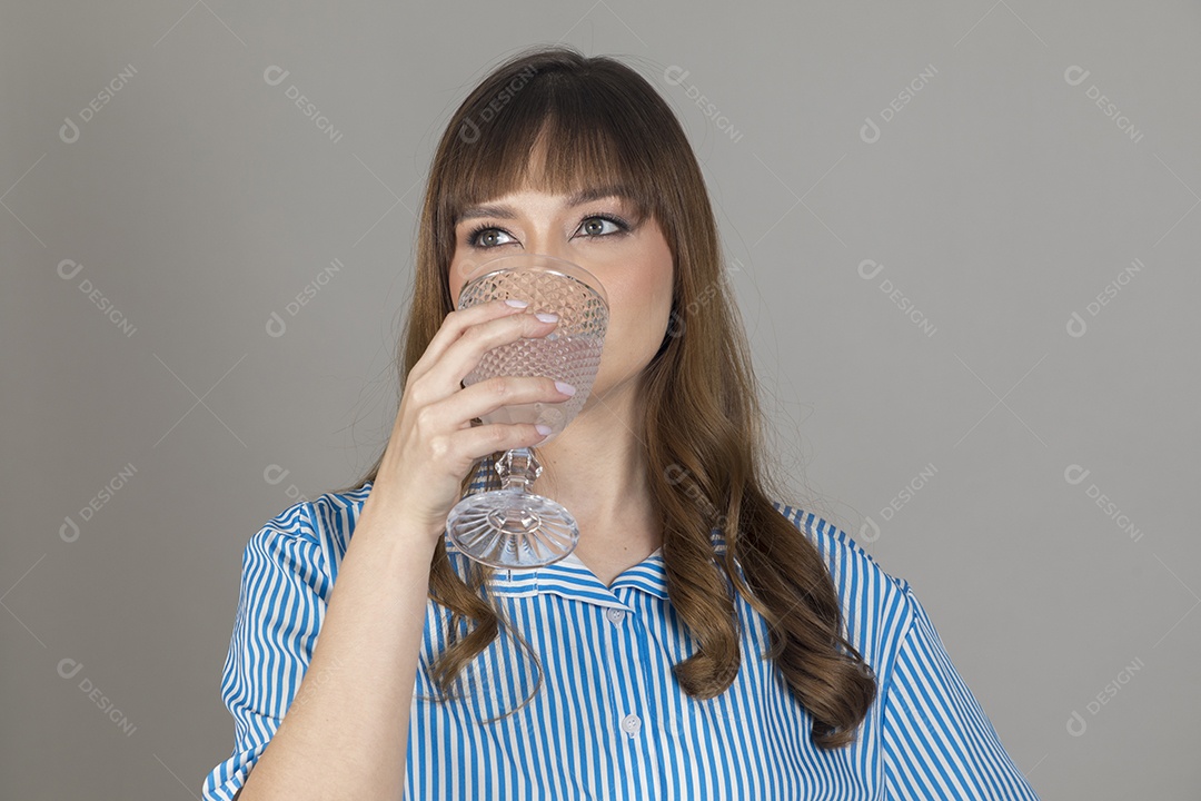 Linda mulher jovem sobre fundo isolado segurando copo de vidro com água
