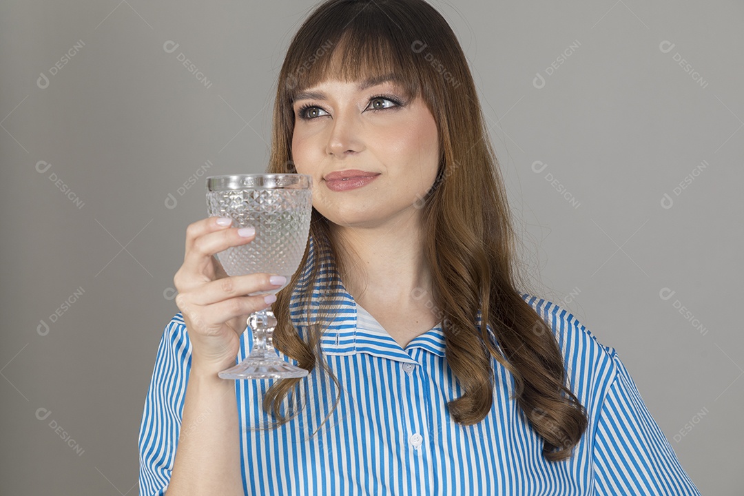 Linda mulher jovem sobre fundo isolado segurando copo de vidro com água