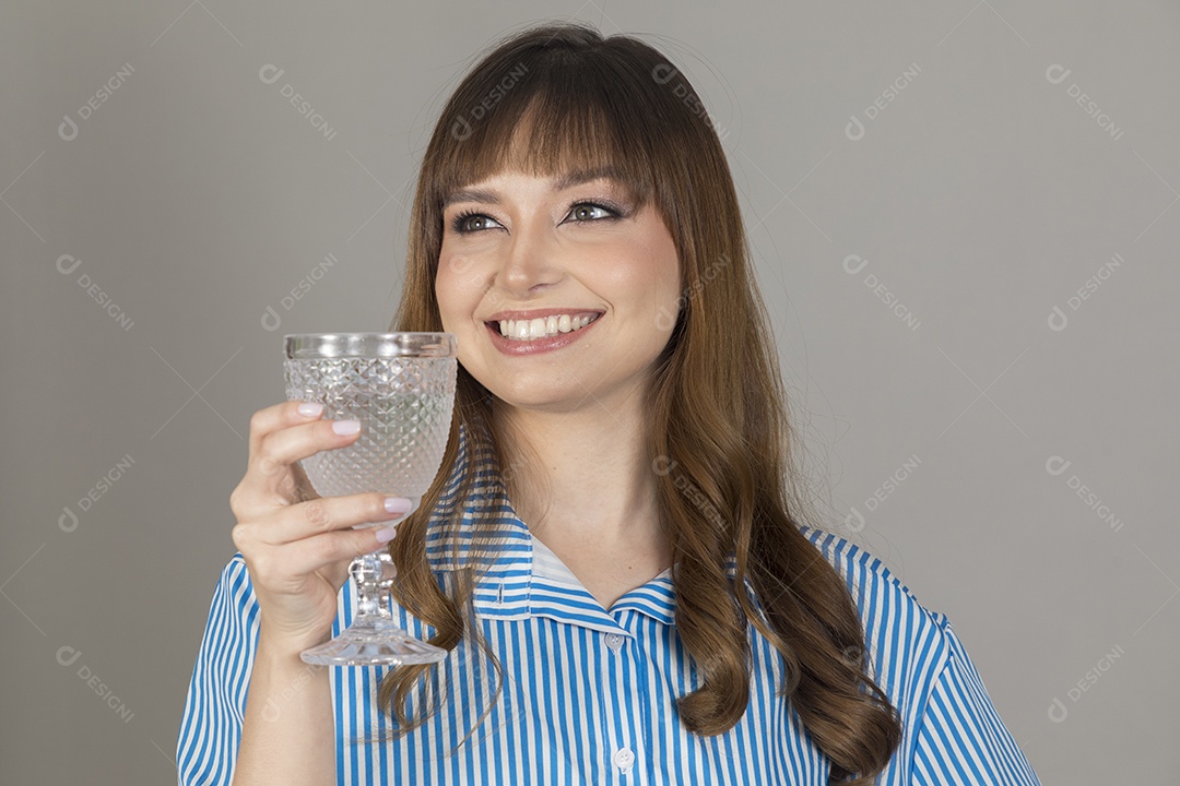 Linda mulher jovem sobre fundo isolado segurando copo de vidro com água