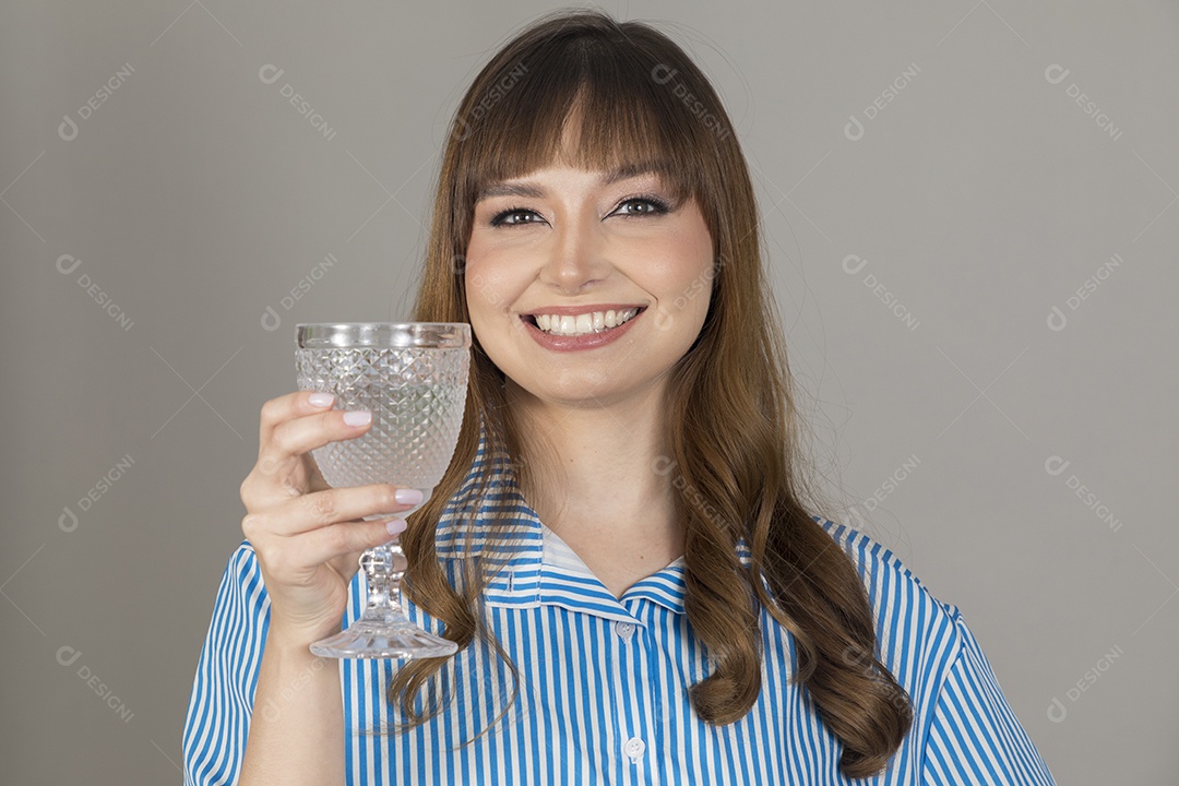 Linda mulher jovem sobre fundo isolado segurando copo de vidro com água