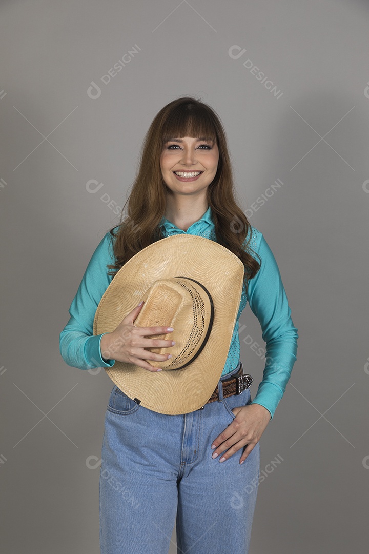 Linda mulher jovem sobre fundo isolado segurando seu chapéu