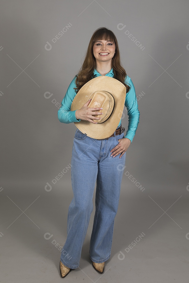 Linda mulher jovem sobre fundo isolado segurando seu chapéu