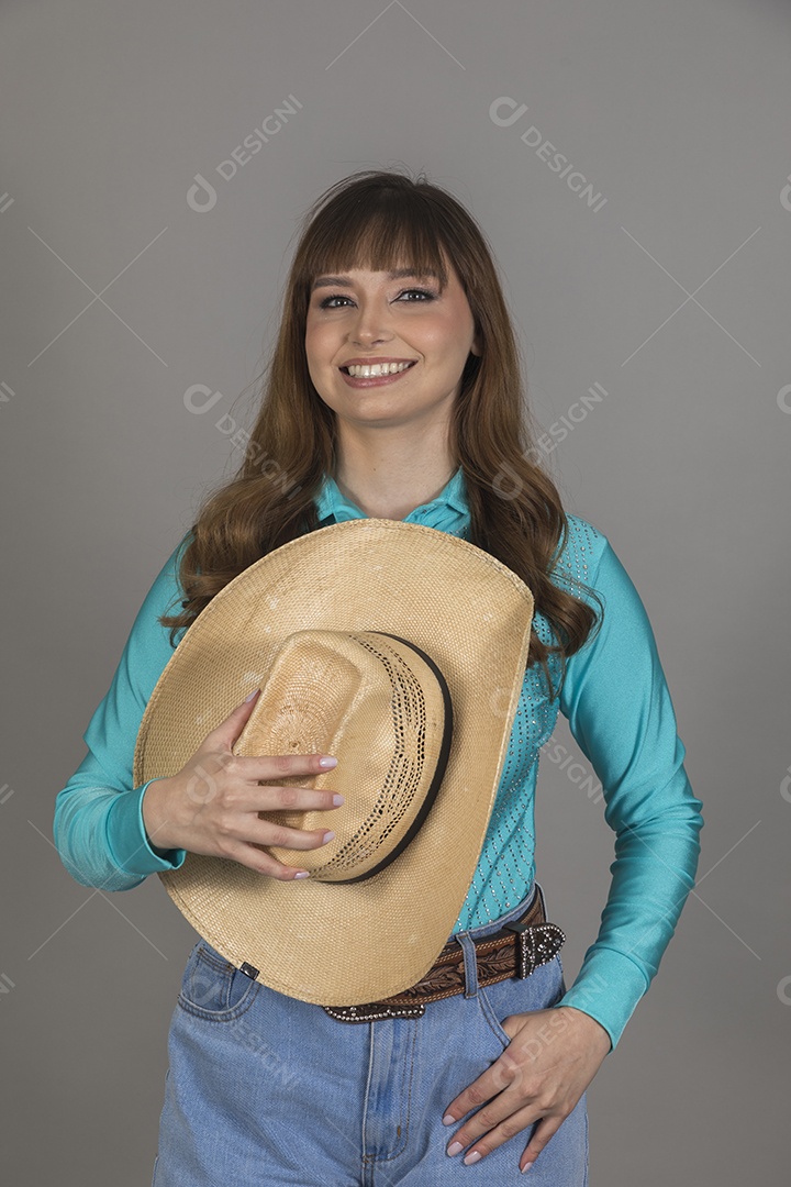Linda mulher jovem sobre fundo isolado segurando seu chapéu