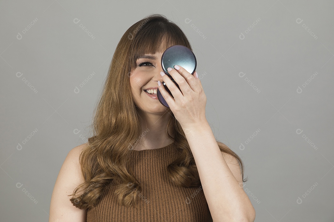 Linda mulher jovem se maquiando sobre fundo isolado branco