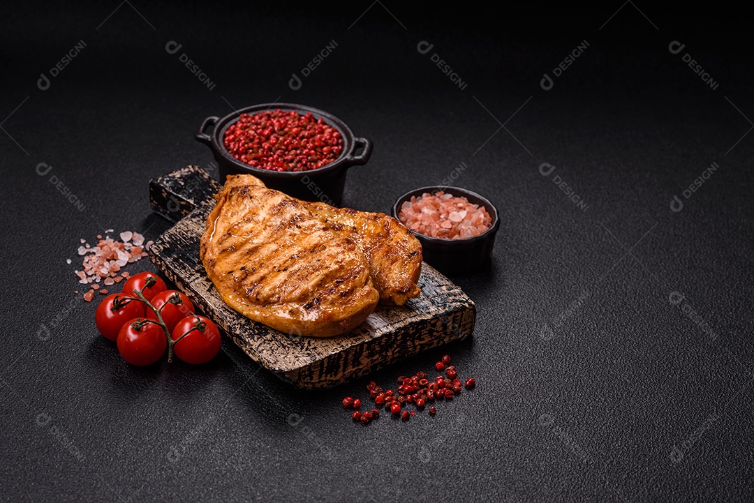 A imagem mostra filés de frango grelhados, acompanhados de temperos e tomates cereja.