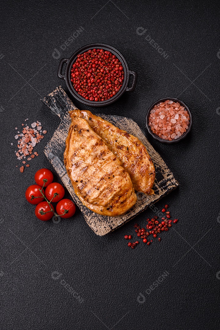 A imagem mostra filés de frango grelhados, acompanhados de temperos e tomates cereja.