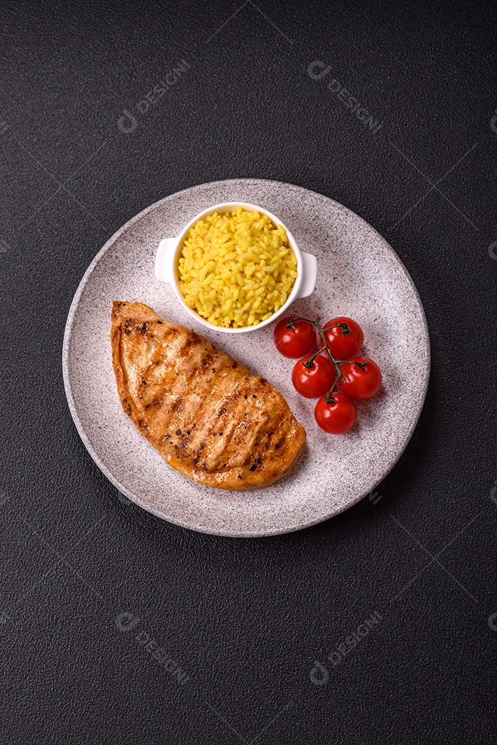A imagem mostra filés de frango grelhados, acompanhados de temperos e tomates cereja.