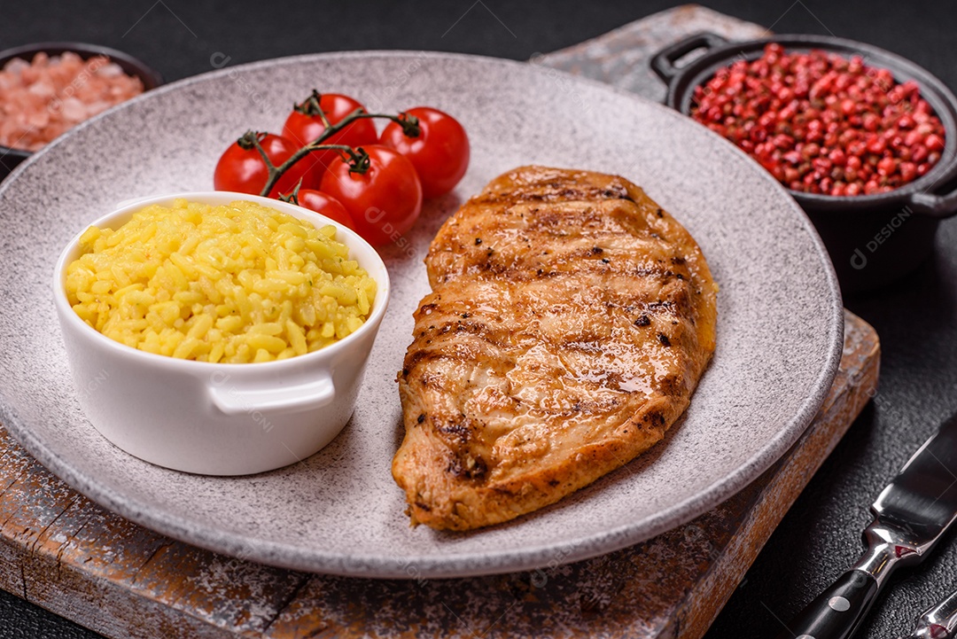 A imagem mostra filés de frango grelhados, acompanhados de temperos e tomates cereja.