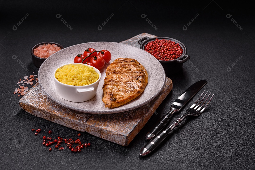 A imagem mostra filés de frango grelhados, acompanhados de temperos e tomates cereja.