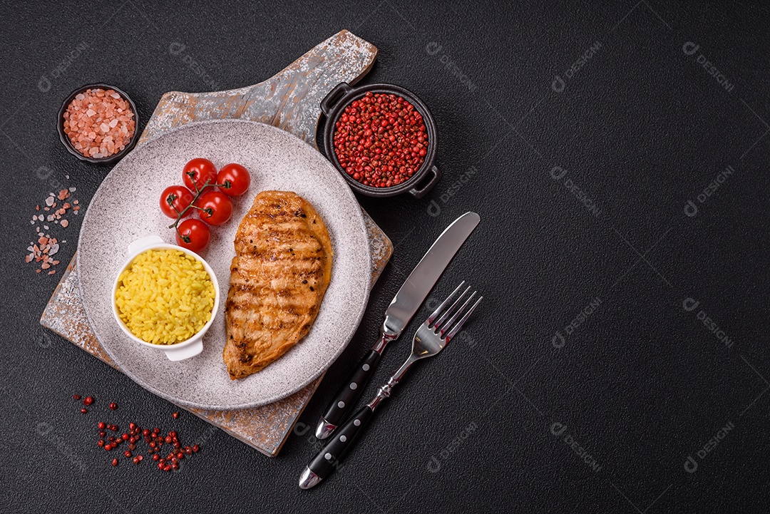 A imagem mostra filés de frango grelhados, acompanhados de temperos e tomates cereja.