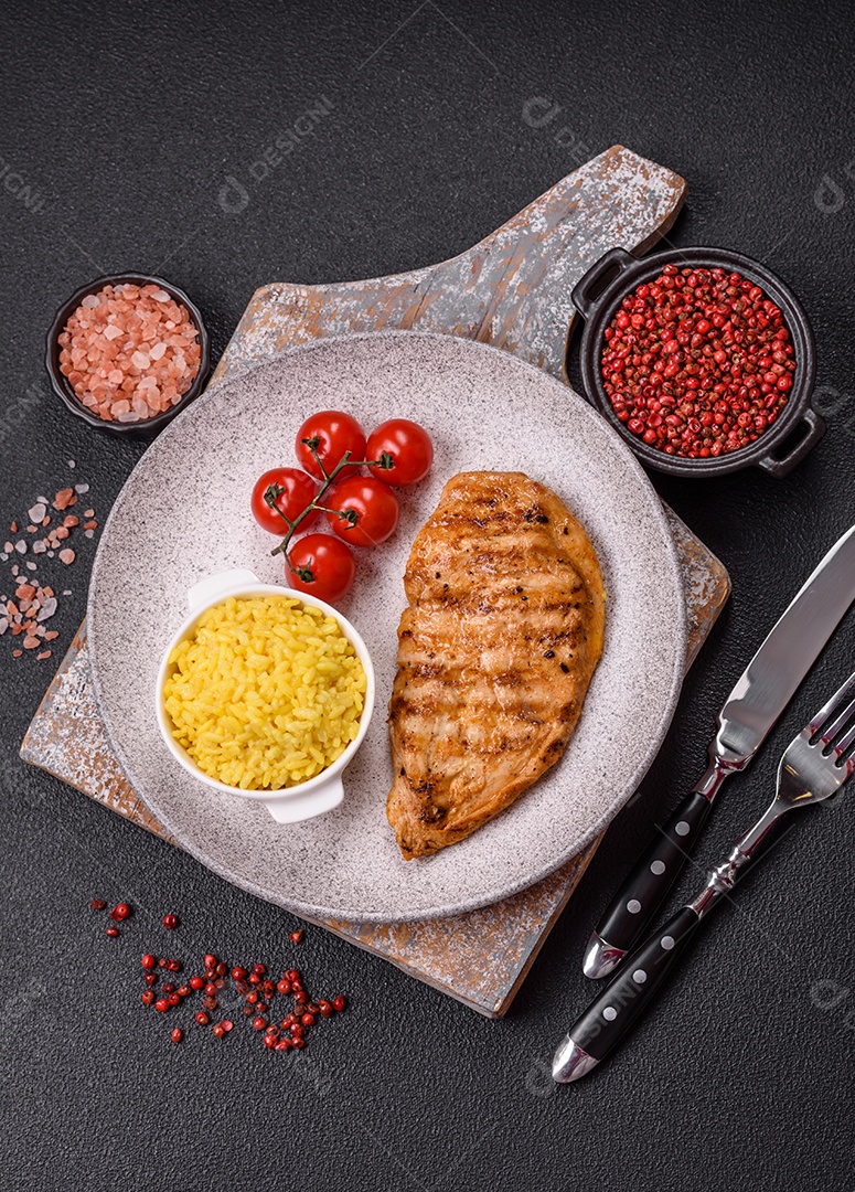A imagem mostra filés de frango grelhados, acompanhados de temperos e tomates cereja.