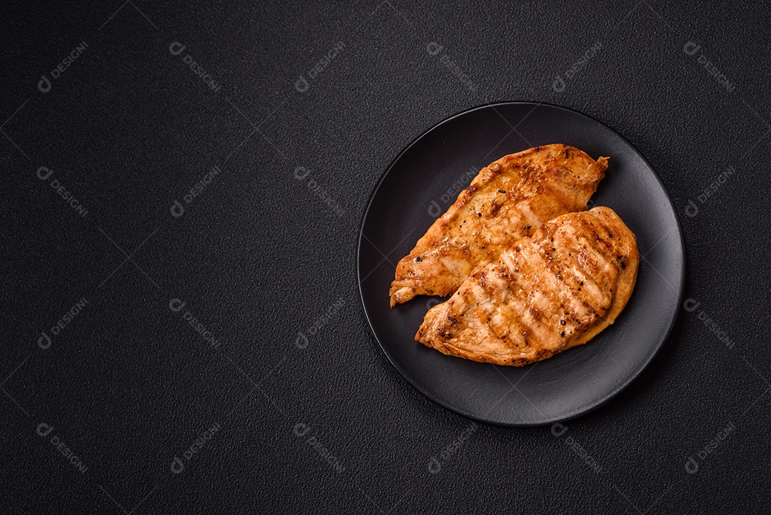 A imagem mostra filés de frango grelhados, acompanhados de temperos e tomates cereja.