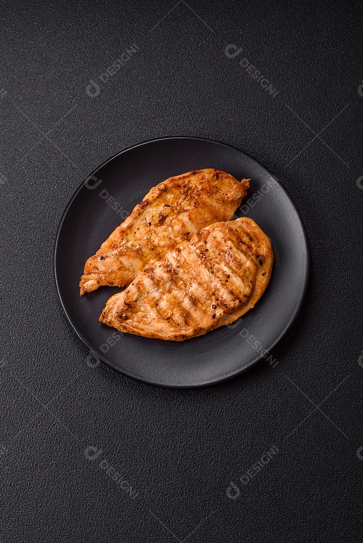 A imagem mostra filés de frango grelhados, acompanhados de temperos e tomates cereja.