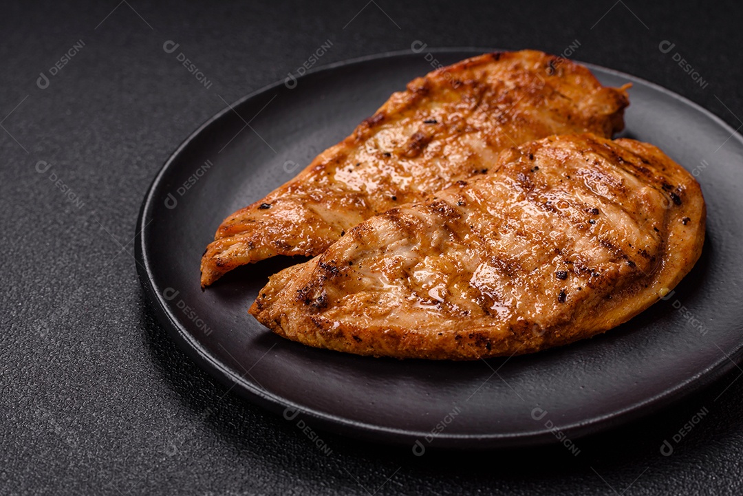 A imagem mostra filés de frango grelhados, acompanhados de temperos e tomates cereja.