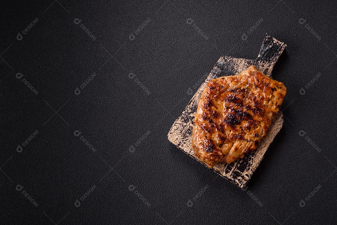 A imagem mostra fatias de carne de porco grelhada, provavelmente lombo ou um corte similar, servidas em uma tábua de madeira.