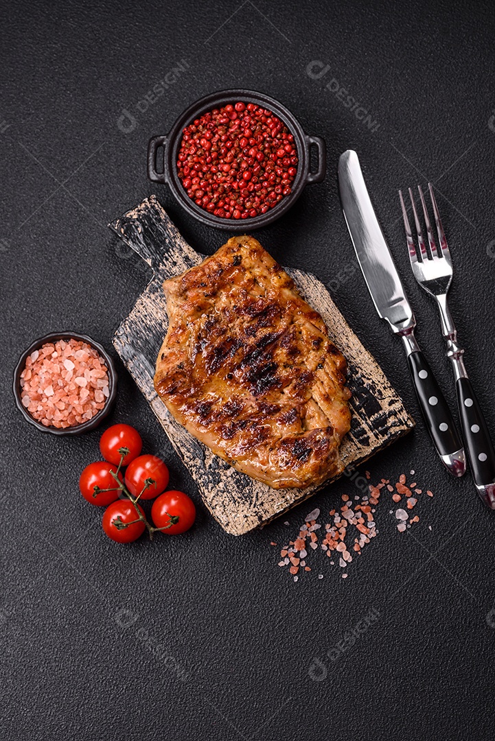 A imagem mostra um pedaço de carne grelhada ou assada, possivelmente frango ou porco, servido em uma tábua de madeira