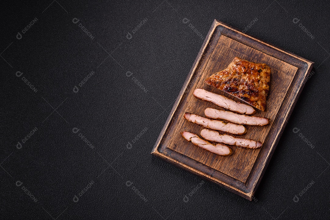 A imagem mostra um pedaço de carne grelhada ou assada, possivelmente frango ou porco, servido em uma tábua de madeira