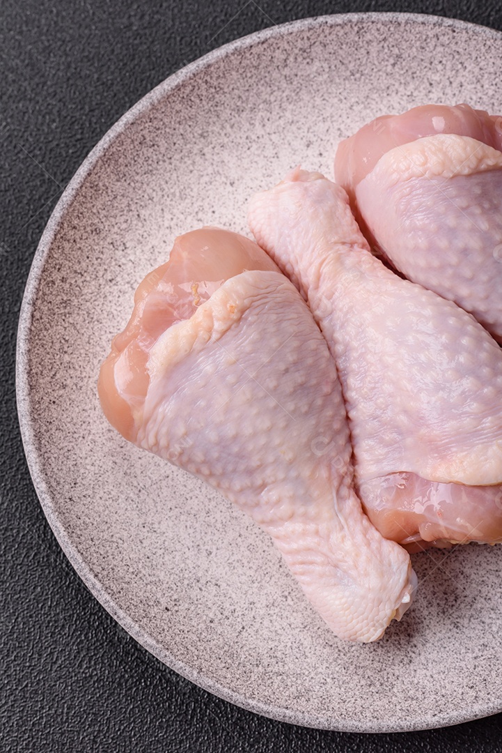 A imagem mostra sobrecoxas de frango cruas.