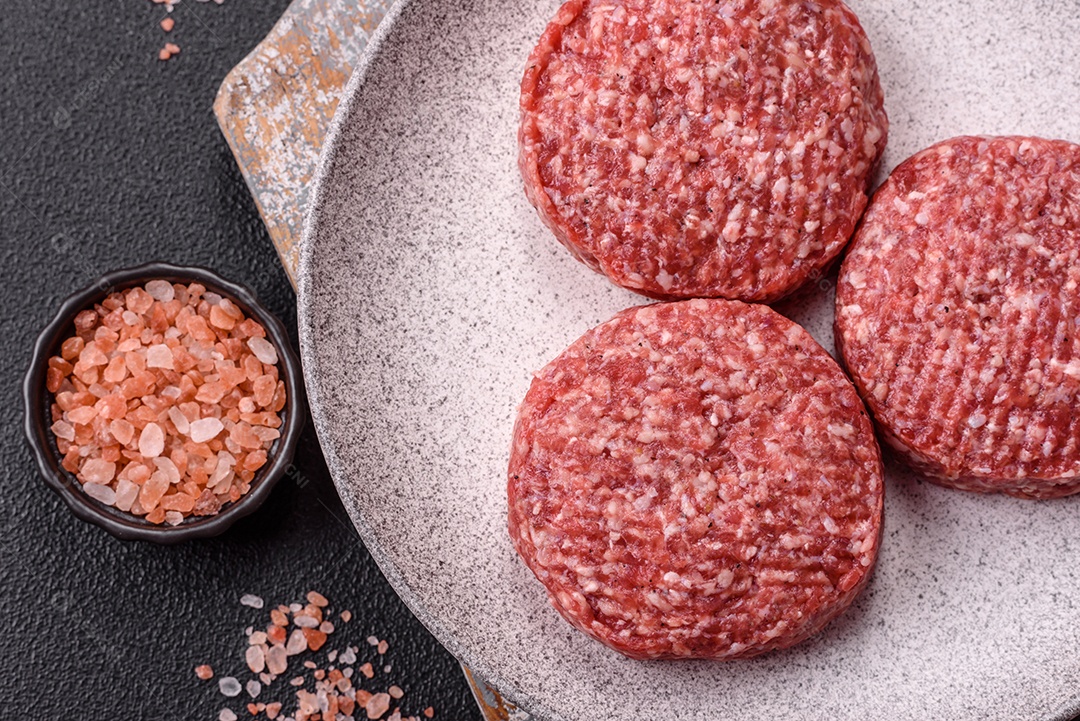 A imagem mostra hambúrgueres de carne crua, prontos para serem cozinhados. Esses patty