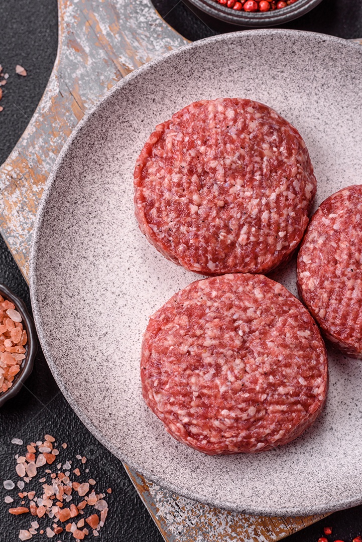 A imagem mostra hambúrgueres de carne crua, prontos para serem cozinhados. Esses patty