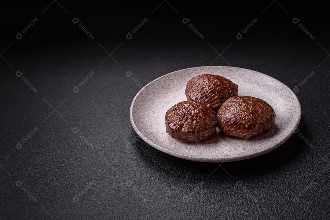 A imagem mostra dois hambúrgueres (ou bifes de carne moída) em um prato preto, acompanhados por tomates cereja