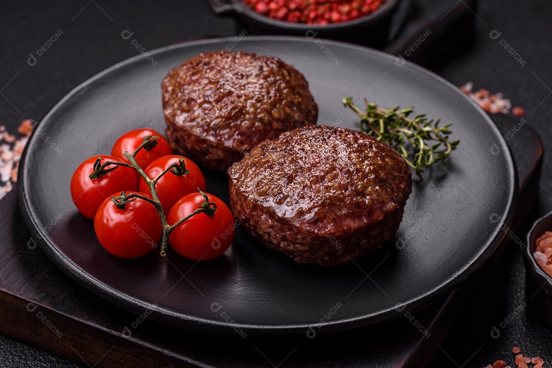 A imagem mostra dois hambúrgueres (ou bifes de carne moída) em um prato preto, acompanhados por tomates cereja