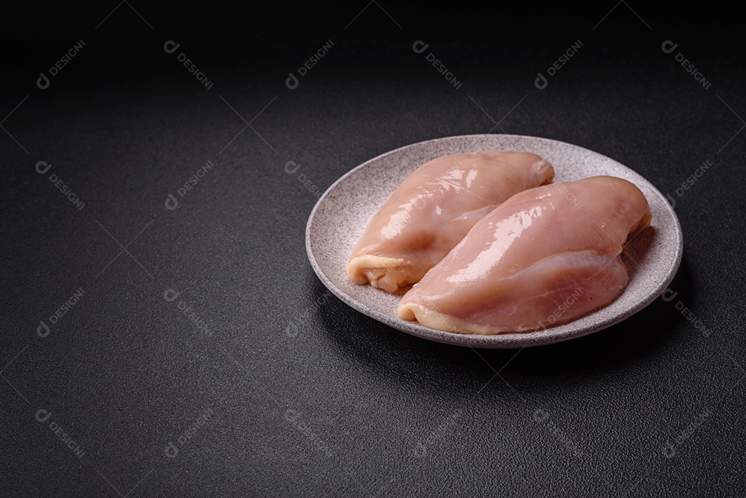 A imagem mostra dois filés de peito de frango crus sobre uma tábua de madeira