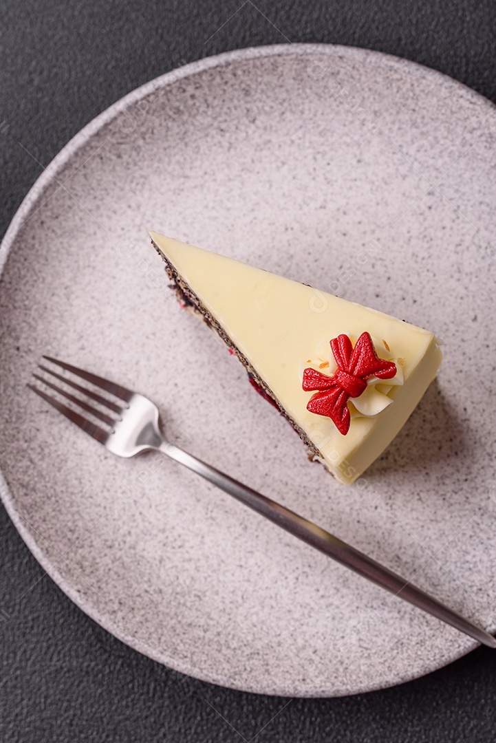 A imagem mostra uma fatia de cheesecake ou um bolo similar, decorado com frutas secas