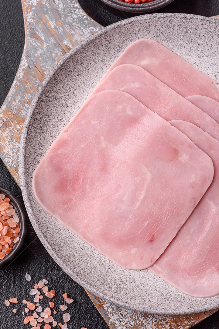 A imagem mostra fatias de presunto, que é um produto de charcutaria feito de carne de porco.